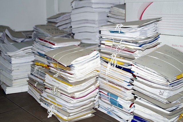 削減すべき職場に積まれた書類の山